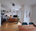 Wohnzimmer - Moder­ne 2‑Zimmer Woh­nung mit Ein­bau­kü­che und Balkon
